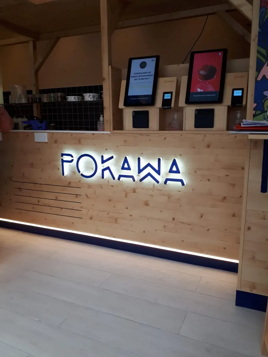 Restaurant Pokawa : logo lumineux sur comptoir